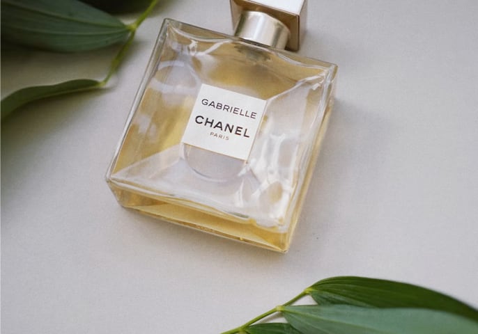 bottle of perfume with green foliage surrounding it